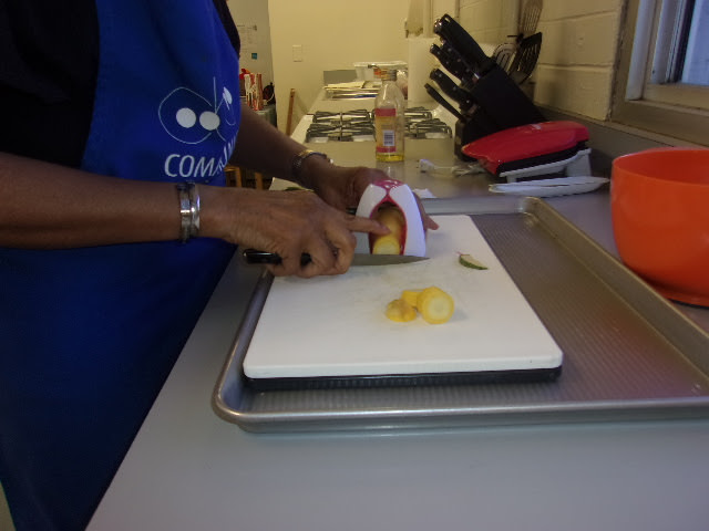 A student slices vegetables using non visual techniques.