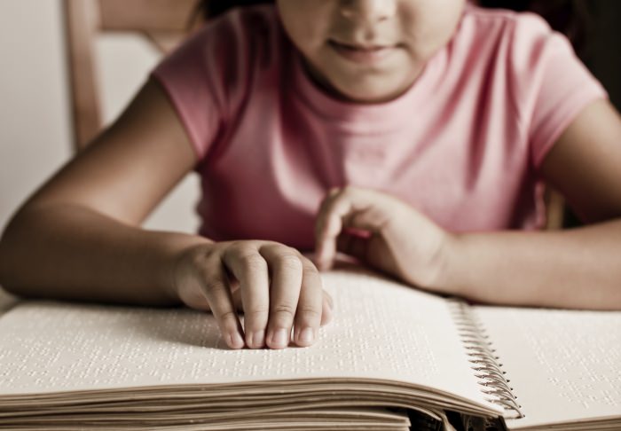 Image of girl reading braille