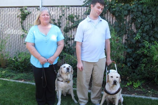 Community Center for the Blind and Visually Impaired Independent Living Skills Instructor Laurie and Adaptive Technology Instructor Hy with Guide Dogs Georgio and Fleetwood.