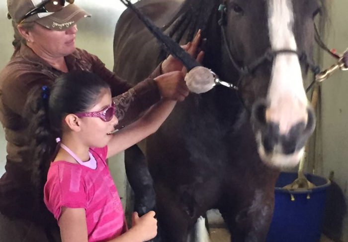 Photo of child and trainer next to horse